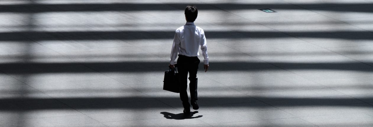 Un homme marche dans la rue en tenant un attaché-case.