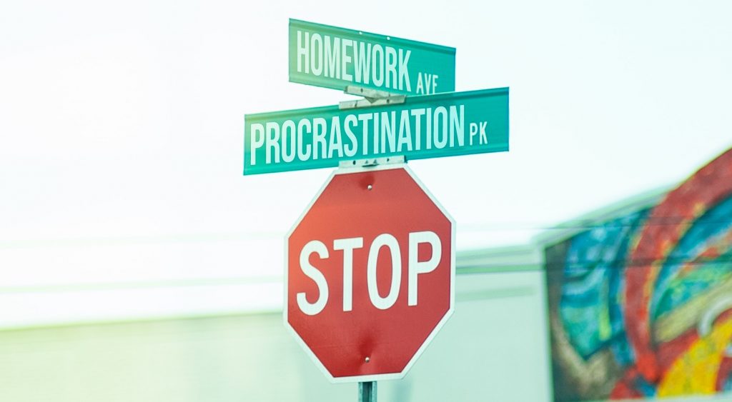 Un panneau STOP au-dessus duquel il y a deux petits panneaux verts avec écrit "homework" et "procrastination".