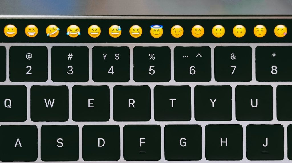 Un claivier de Macbook avec des emojis sur la touchbar.