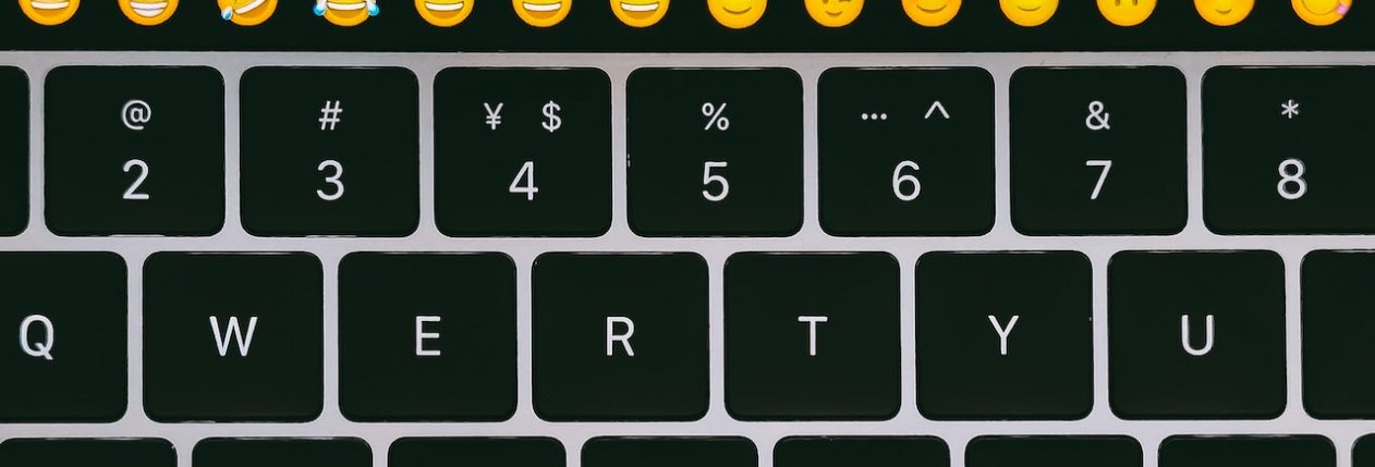 Un claivier de Macbook avec des emojis sur la touchbar.