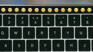 Un claivier de Macbook avec des emojis sur la touchbar.