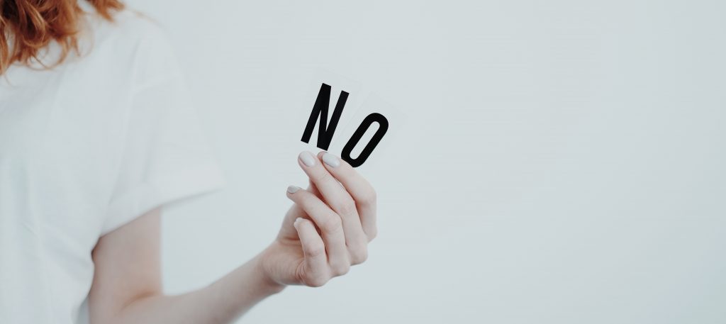 Une femme tient deux lettres dans ses mains "N" et "O".