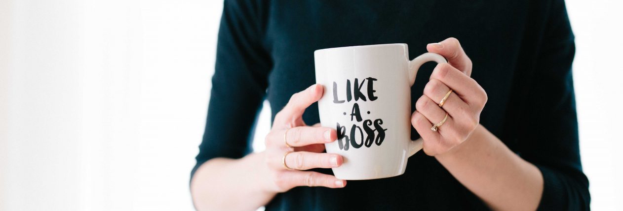 Une femme porte une tasse avec écrit "Like a Boss"