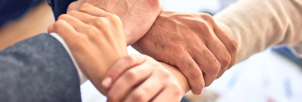 4 personnes se tiennent le poignet de sorte à créer un lien en carré.