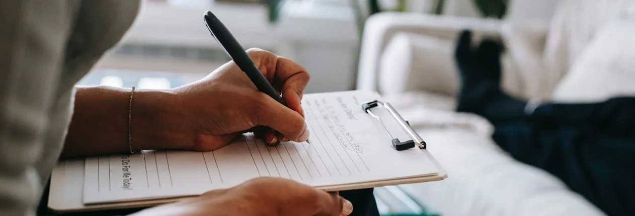 Une femme écrit quelque chose sur un paper-clip.
